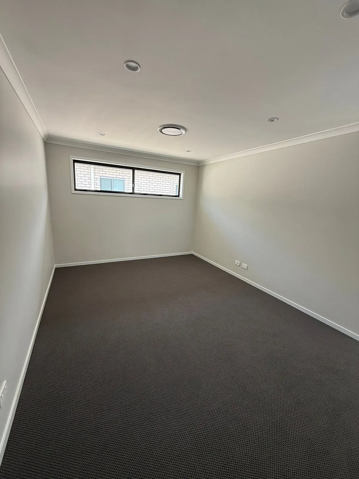 An empty bedroom in Sunnybank, Brisbane, with freshly painted warm grey walls, a white ceiling, cornices and skirting boards